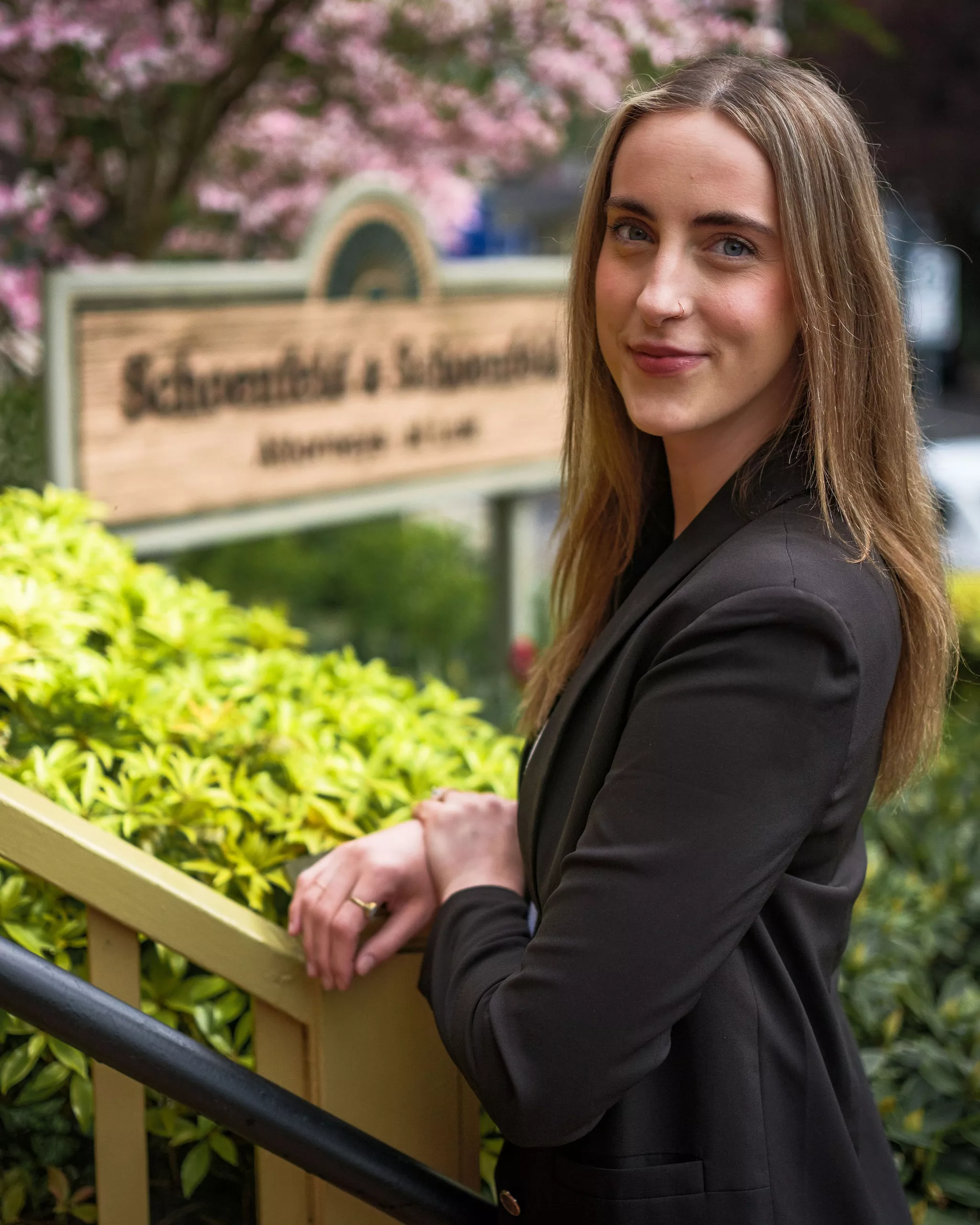 Lilly Cichon standing outside a law office near the Schoenfeld & Schoenfeld sign