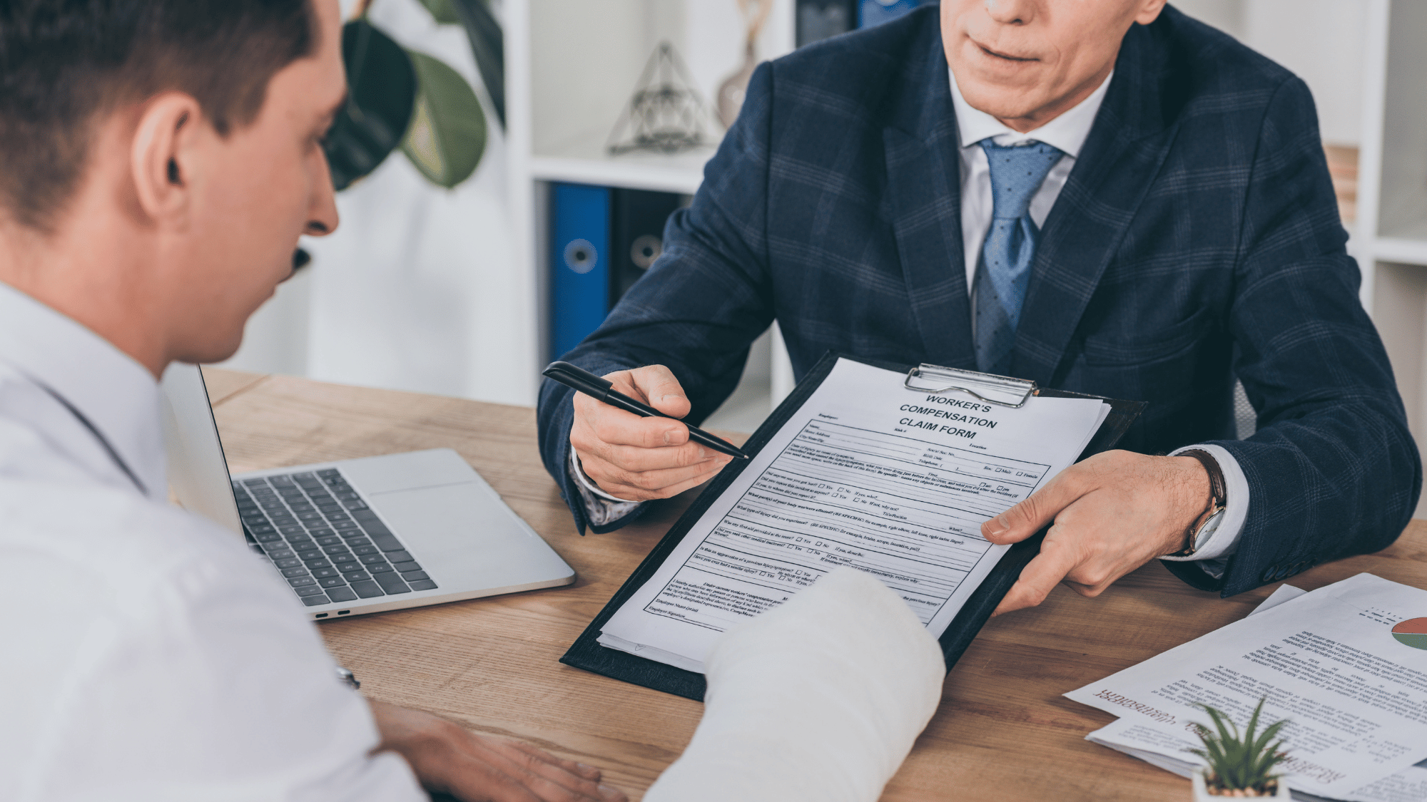 Attorney reviewing an Oregon workers' compensation claim form with an injured worker during a legal consultation.