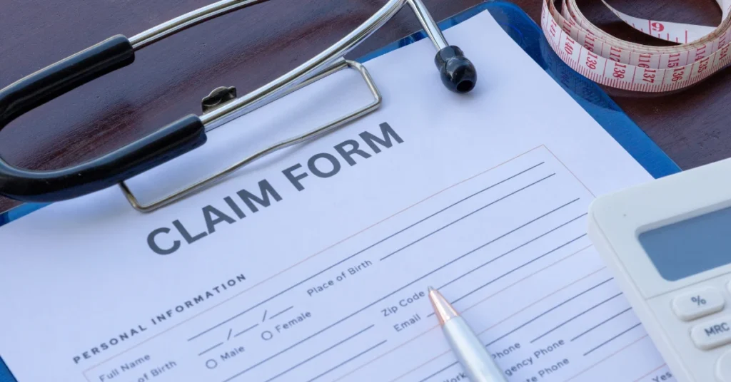 Workers' compensation claim form with medical equipment and paperwork related to an occupational hearing loss claim in Oregon.