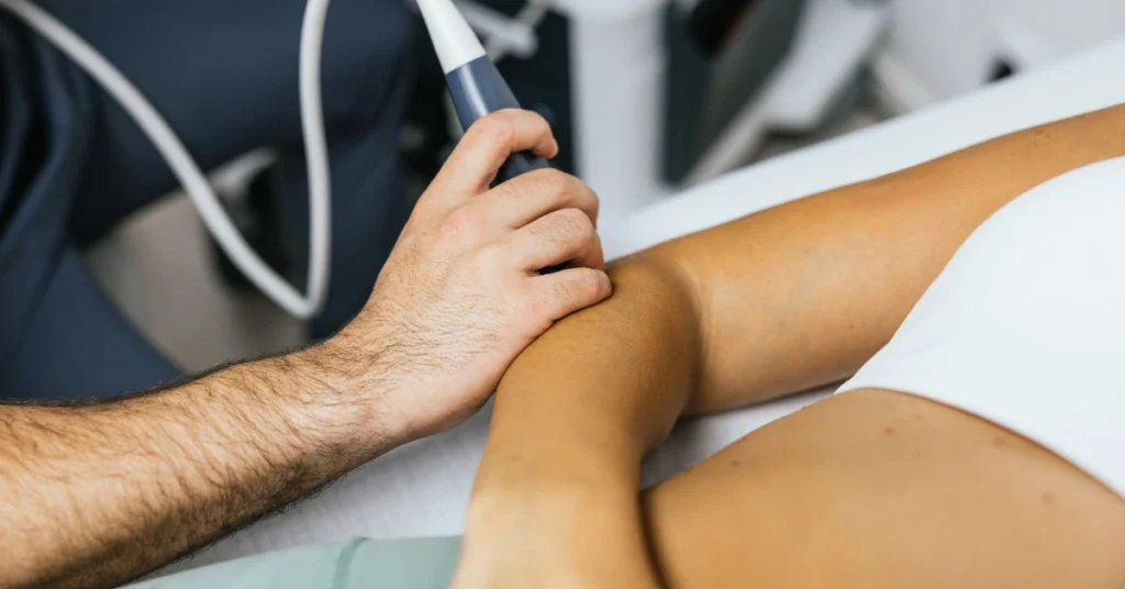 Medical provider performing an ultrasound examination on an injured arm to diagnose a workplace injury for an Oregon workers' compensation claim.