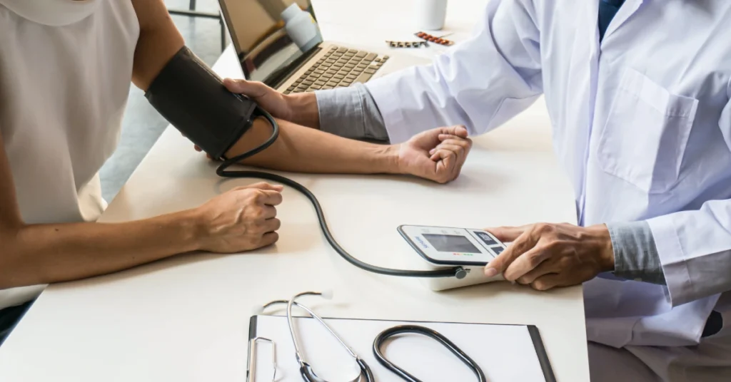 Doctor checking a patient's blood pressure during a medical evaluation related to an Oregon workers' compensation injury claim.