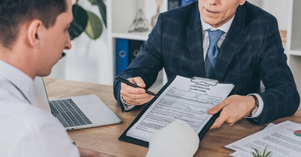 Attorney reviewing a workers' compensation claim form with an injured employee during an Oregon work injury consultation.